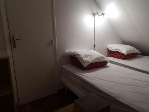 a bed with two pillows on it in a room at Et pourquoi pas des vacances naturistes à la Jenny ? in Le Porge