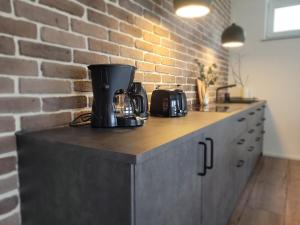 a kitchen with a counter with a brick wall at Ferienwohnung am Ohmbachsee in Gries