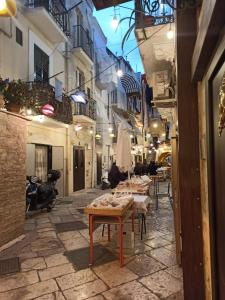een straat met tafels en stoelen in een steegje bij Corte Barone in Bari