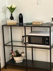 a black stand with a microwave and a bowl of flowers at A Casa di Gioia in Castel di Sangro