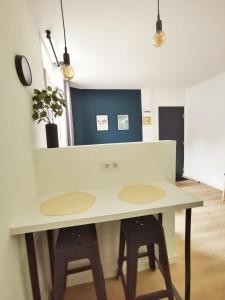 a white table with two stools in a room at L'alcôve (Centre - Gare - Commerces) in Lens