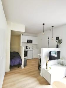 a white room with a bed and a desk at L'alcôve (Centre - Gare - Commerces) in Lens