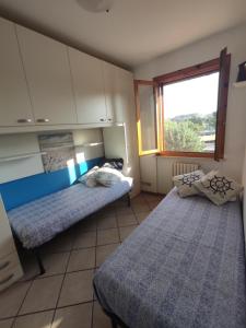 a bedroom with two beds and a window at PASSIONE MARINARA-Trilocale con ARIA CONDIZIONATA e Parcheggio a Marcelli in Numana