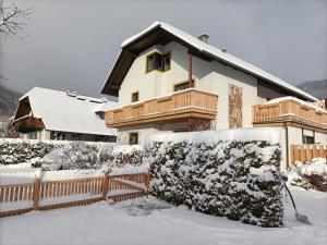 a house with a fence covered in snow at Haus Katris in Mauterndorf