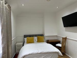 a bedroom with a bed and a flat screen tv at Double Room With Free WiFi Keedonwood Road in Bromley