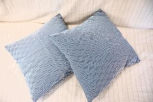 two gray pillows sitting on top of a bed at Seaside Serenade 2 suite in Ermoupoli