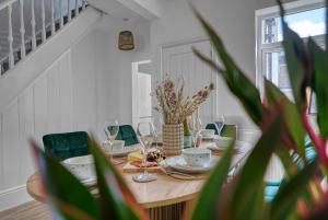 a dining room table with plates and glasses and a plant at Modern Townhouse 3-BR, Sleeps 8, Central Location by Blue Puffin Stays in Portsmouth