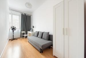 ein Wohnzimmer mit einem Sofa und einem Schreibtisch in der Unterkunft Old Town 5-Bedroom Apartment in Warschau