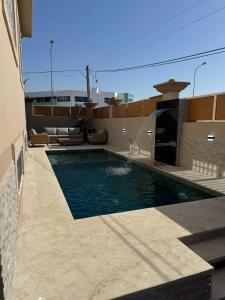 a swimming pool on the side of a house at Spacieuse villa familiale avec piscine Founty in Agadir