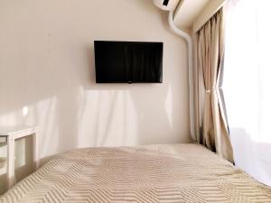 a bedroom with a bed with a television on the wall at Z87新宿最中心 東新宿站5分-Shinjuku center 5 mins to Station, Max 3P 新宿 涉谷 表参道 池袋 上野 代代木 银座 原宿 in Tokyo