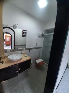 uma casa de banho com um lavatório, um WC e um espelho. em Pousada Chez Moi em Cabo Frio