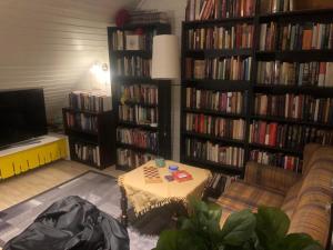 a living room with a book shelf filled with books at Large house with spectacular view in Tromsø