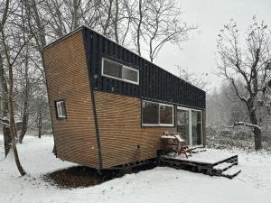Una pequeña casa sentada en la nieve en el bosque en POP Tiny House Nagymaros en Nagymaros