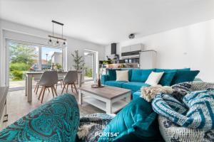 ein Wohnzimmer mit einem blauen Sofa und einem Tisch in der Unterkunft Ferienwohnung Salzbrise Fehmarn in Fehmarn