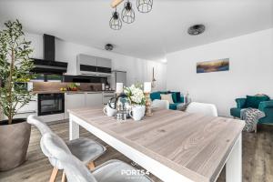 eine Küche und ein Esszimmer mit einem Holztisch und Stühlen in der Unterkunft Ferienwohnung Salzbrise Fehmarn in Fehmarn + 18 Fotos