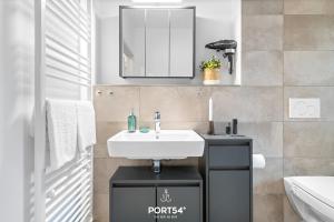 ein Badezimmer mit einem weißen Waschbecken und einem Spiegel in der Unterkunft Ferienwohnung Salzbrise Fehmarn in Fehmarn