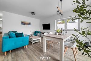ein Wohnzimmer mit einem blauen Sofa und einem Tisch in der Unterkunft Ferienwohnung Salzbrise Fehmarn in Fehmarn