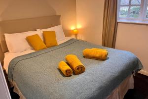 a bedroom with a bed with yellow towels on it at Green Cottage in grounds of Grade II* Frognal Farmhouse in Sittingbourne