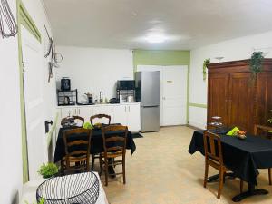 a kitchen with a table with chairs and a refrigerator at O fil de l'eau in Tétaigne