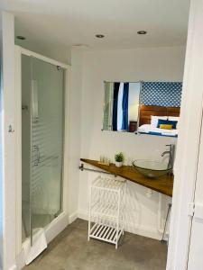 a bathroom with a glass shower and a sink at O fil de l'eau 
