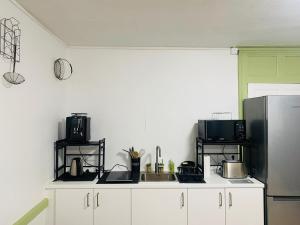 a kitchen with white cabinets and a black refrigerator at O fil de l'eau 