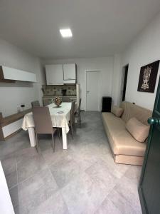 ein Wohnzimmer mit einem Tisch und einem Sofa in der Unterkunft Casa vacanza isola delle femmine Sea residence in Isola delle Femmine