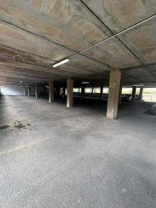 an empty parking lot with concrete pillars in a parking garage at Casa vacanza isola delle femmine Sea residence in Isola delle Femmine