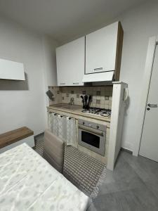 a small kitchen with a stove and a refrigerator at Casa vacanza isola delle femmine Sea residence in Isola delle Femmine