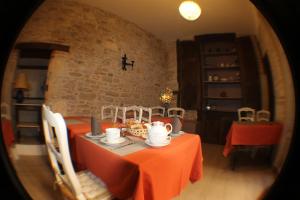 a dining room with a table with an orange table cloth at Hotel Raymond VII in Cordes-sur-Ciel
