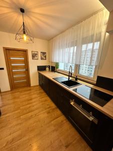 a kitchen with black cabinets and a sink and a window at Stratený kľúč in Revúca