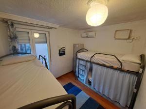 een kamer met 2 bedden en een raam bij El Cascabel in Granada