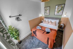 Un dormitorio con una cama con una manta naranja. en Stunning Design 3-Bedroom Townhouse Retreat in Southsea, Sleeps 8, Chic and Spacious with Free Parking Permit, WORK CONTRACTORS SPECIAL OFFER AVAILABLE! - by Blue Puffin Stays, en Portsmouth