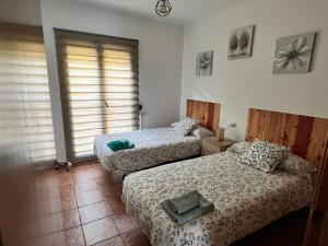 a bedroom with two beds and a window at Alojamiento Rural El Morenal in Tragacete