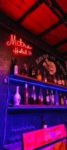 a bar with a shelf filled with bottles of alcohol at Mitra Hostel Vagator in Vagator