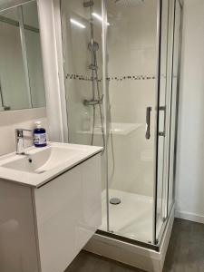 biała łazienka z prysznicem i umywalką w obiekcie Welcome Home w mieście Vert-le-Grand