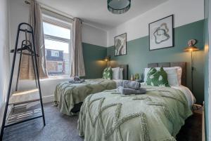 twee bedden in een kamer met groene en witte muren bij Modern Townhouse 3-BR, Sleeps 8, Central Location by Blue Puffin Stays in Portsmouth