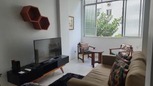 a living room with a couch and a flat screen tv at Vista mar entre Copacabana Ipanema e Arpoador in Rio de Janeiro