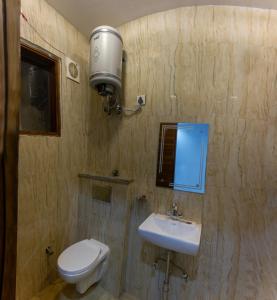 uma casa de banho com um WC e um lavatório em Hotel NEU-NEST em Rishikesh