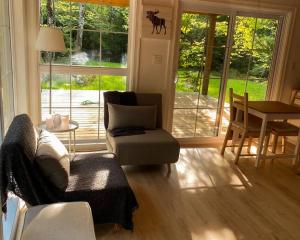 uma sala de estar com um sofá e uma mesa em Moose Cabin - Cozy Forest Retreat nearby Lake em East Kemptville