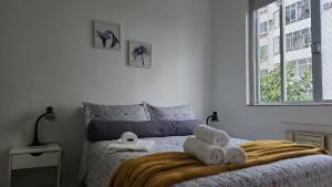 a bedroom with a bed with towels on it at Vista mar entre Copacabana Ipanema e Arpoador in Rio de Janeiro