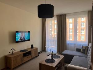 a living room with a couch and a tv at Apartament w centrum Gdańska in Gdańsk