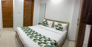 um quarto com uma grande cama branca com almofadas em Hotel NEU-NEST em Rishikesh