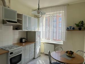 a kitchen with a table and a white refrigerator at Apartament w centrum Gdańska in Gdańsk