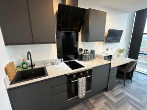 a kitchen with a sink and a stove top oven at Graduation Studios in Beeston