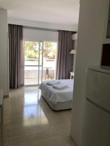 - une chambre avec un lit et une porte coulissante en verre dans l'établissement Estudio Torre de Andalucía, à Marbella