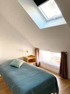 a bedroom with a bed and a skylight at L'appartementducroisic - Sur le port, vue mer in Le Croisic