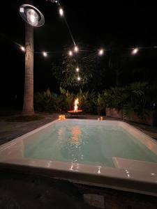 a swimming pool at night with a fire in the background at Casa de Ali in Pereira