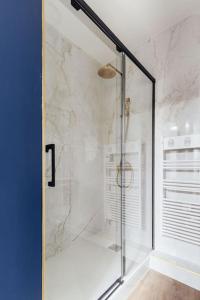 W łazience znajduje się prysznic ze szklanymi drzwiami. w obiekcie Modernité près de Disneyland Paris w mieście Serris