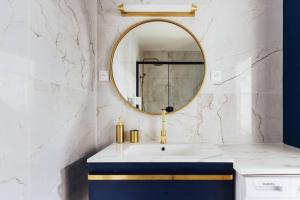 y baño con lavabo azul y espejo. en Modernité près de Disneyland Paris en Serris
