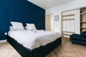 1 dormitorio con 1 cama grande y pared azul en Modernité près de Disneyland Paris en Serris